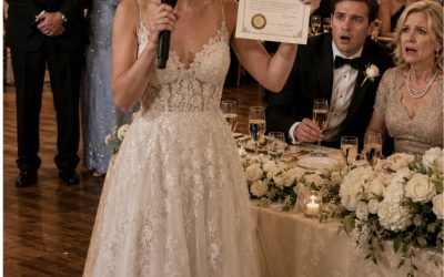 Le jour de mon mariage, la famille de mon mari a pris les neuf places à la table d’honneur et a relégué mes parents près des portes de la cuisine comme du personnel—puis sa mère a ricané : ‘Ils ont l’air si pauvres’, et mon mari a acquiescé… alors je suis montée sur scène, j’ai pris le micro et j’ai prononcé cinq mots qui ont arrêté son verre de champagne à mi-chemin de sa bouche.